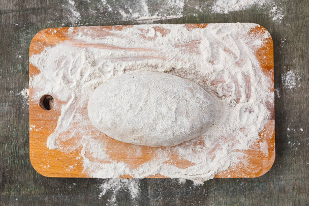 Dough in flour for rye bread on a wooden board - Foto, imagen