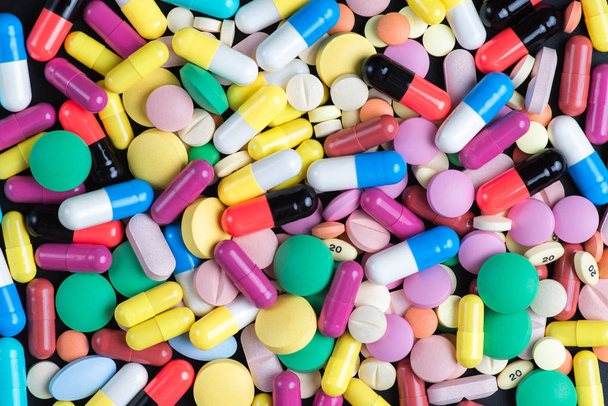 Comprimidos y pastillas de color sobre un fondo naranja
 - Foto, imagen