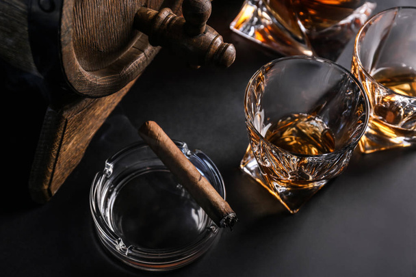 Gläser kalten Whiskys mit Zigarre und Fass auf dunklem Hintergrund - Foto, Bild