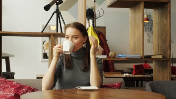 Mujer joven se reúne en el café para dos amigos bebiendo una taza de café
. - Metraje, vídeo