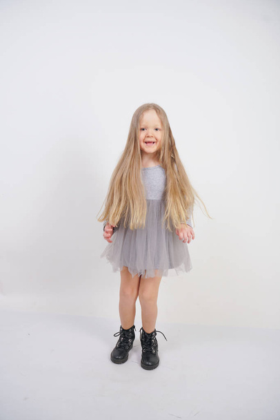 cute caucasian baby girl with long blond hair stands on white background in Studio - Fotografie, Obrázek