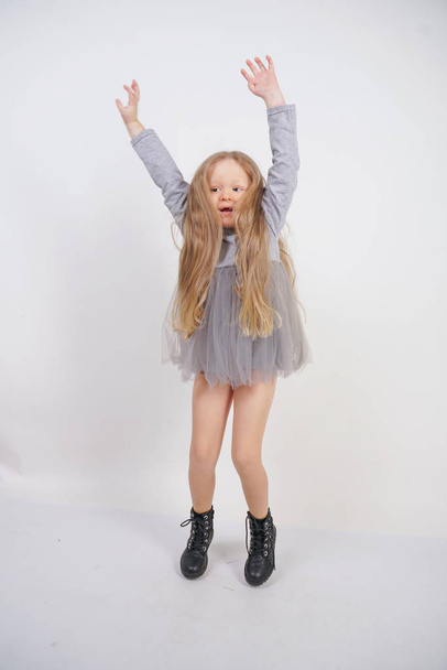 cute caucasian baby girl with long blond hair stands on white background in Studio - Φωτογραφία, εικόνα