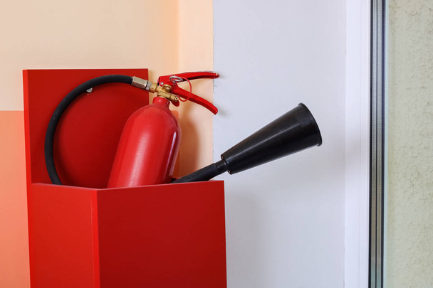 Красный цилиндр и пожарный шланг вблизи
 - Фото, изображение