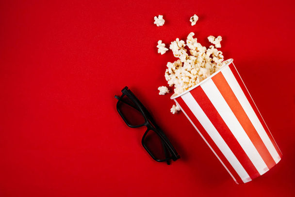 Movie night concept - pop corn, glasses, bright red background - Фото, изображение