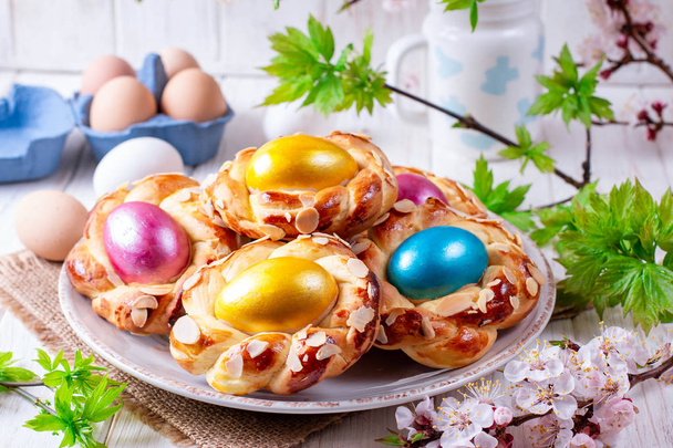Anéis de pão de Páscoa italianos tradicionais, decorados com ovos coloridos
 - Foto, Imagem