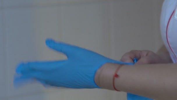 Medic wears gloves The doctor puts on a blue sterilized medical glove - Filmagem, Vídeo