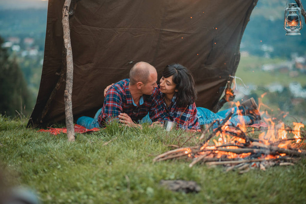 krásný pár při západu slunce ve stanu u ohně - Fotografie, Obrázek