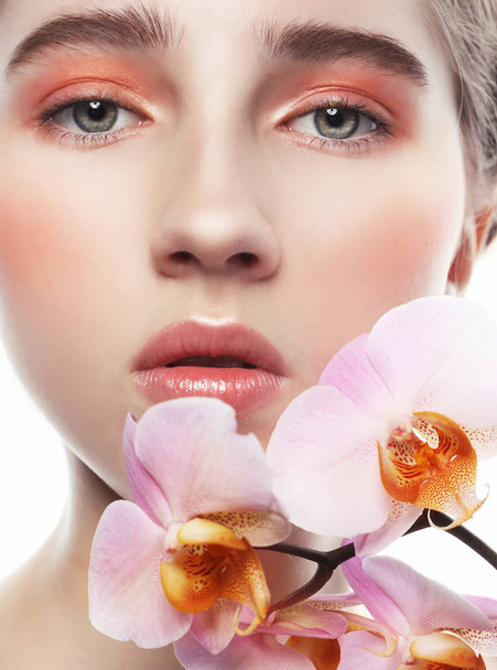 modelo com maquiagem perfeita e flores rosa
 - Foto, Imagem