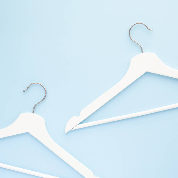 White wooden hangers on blue background - Foto, immagini