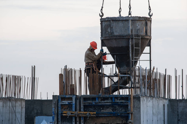 construction workers at a construction site pouring concrete - Fotoğraf, Görsel