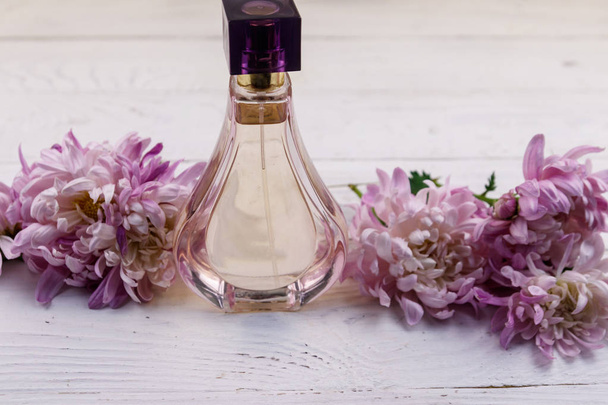 Perfume de mujer con flores sobre fondo blanco de madera
 - Foto, imagen