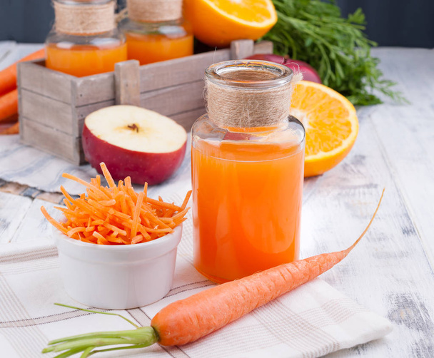 Fresh juice of carrot, apple, orange and lemon. Carrots with lea - Valokuva, kuva