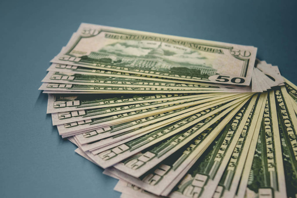 Paczka 50 banknotów dolarów izolowanych na niebieskim tle - Zdjęcie, obraz