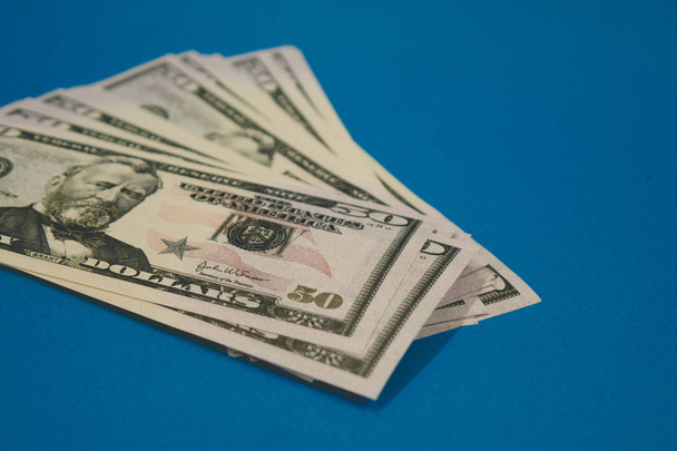 Paquete de billetes de cincuenta dólares aislados sobre fondo azul
 - Foto, imagen
