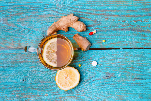 Холодні ліки, чай, лимон та імбир на дерев'яному синьому фоні
 - Фото, зображення