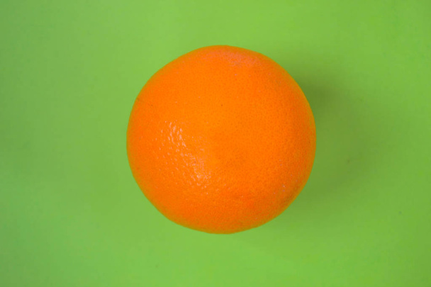Isolated orange orange against a green background - Fotografie, Obrázek