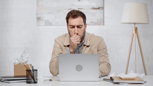 handsome bearded man typing on laptop and coughing in modern office  - Footage, Video