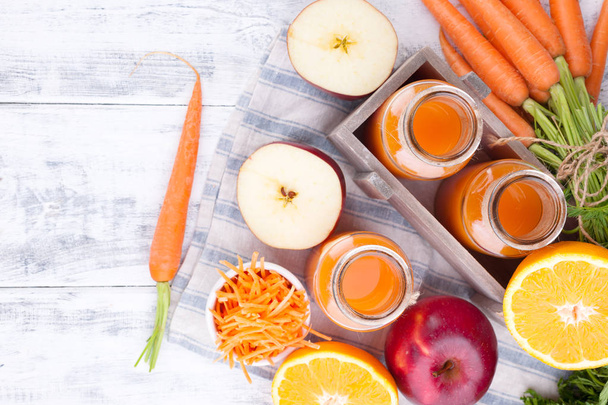 Fresh juice of carrot, apple, orange and lemon. Carrots with lea - Valokuva, kuva
