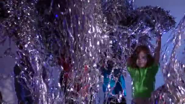 Jumping children throwing up tinsel on gray background, slow motion. - Footage, Video