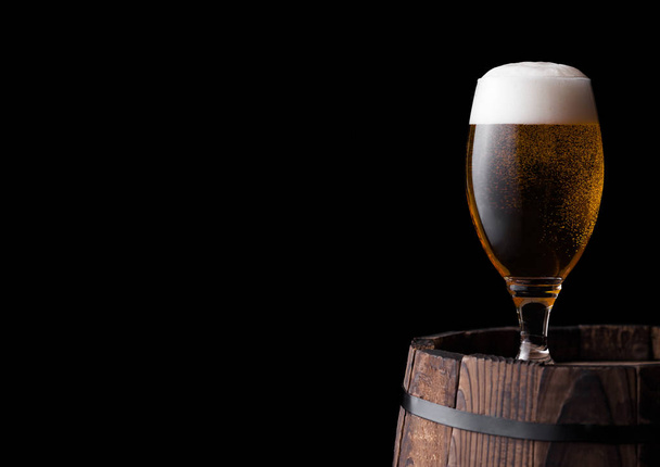 Cold glass of craft beer on old wooden barrel - Фото, зображення