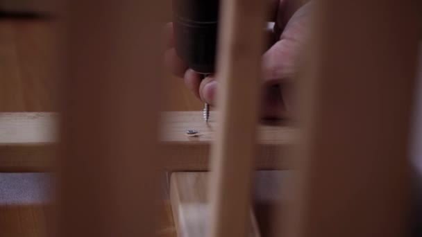 Mans blote handen zijn met behulp van moderne elektronische schroevendraaier om planken te verbinden - Video