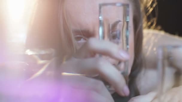 Female losing consciousness on bar counter after vodka shots, binge drinking - Video, Çekim