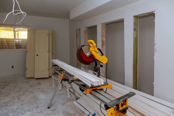 Bouw renovatie home snijden houten trim board op met cirkelzaag. - Foto, afbeelding