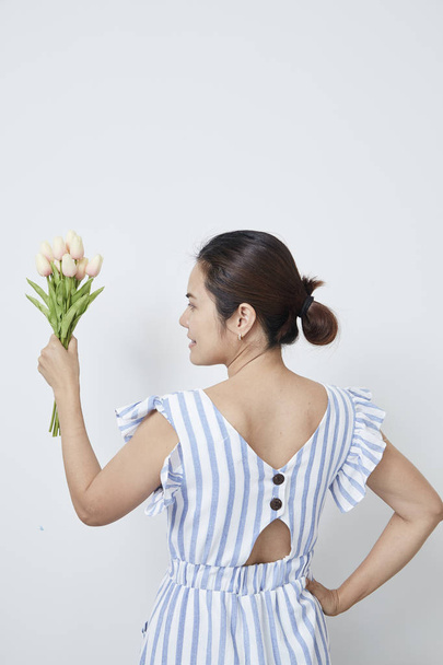 Beautiful woman holding bouquet of tulips - 写真・画像