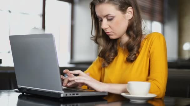 Blogger mujer trabajando en laptop en cafetería, publicando publicación en red social
 - Imágenes, Vídeo