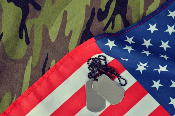 Bandiera americana e distintivi dei soldati sul tessuto mimetico. Veterani o Memorial Day Concept
. - Foto, immagini