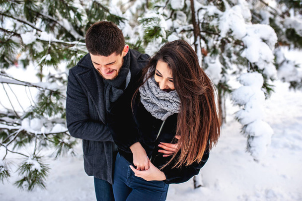 Tender couple hugging in cold winter park - Fotoğraf, Görsel