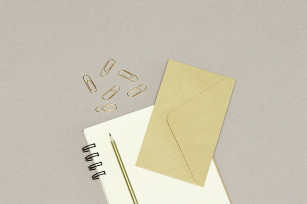 The kraft envelope, notes, golden pencil & paper clips, on the white  background - Photo, Image