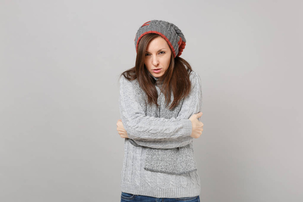 Zamrażanie młodej kobiety w szarym swetrze, kapelusz szalik trzymając ręce fo - Zdjęcie, obraz
