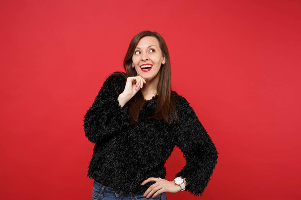 Sognante giovane donna in maglione di pelliccia nera guardando in alto, mettere mano pro
 - Foto, immagini