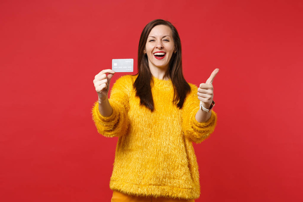 Laughing young woman in yellow fur sweater showing thumb up, hol - Fotografie, Obrázek