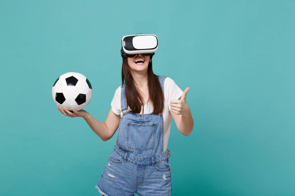 Uśmiechnięta kobieta fan piłki nożnej w zestawie słuchawkowym trzyma piłkę nożną, Pants - Zdjęcie, obraz