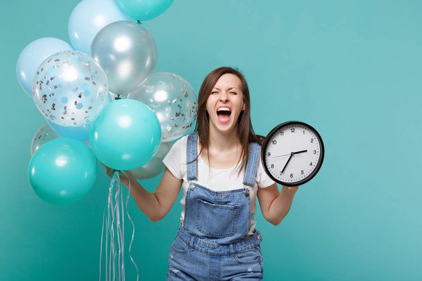Crazy crier jeune femme en denim vêtements tenant horloge ronde
 - Photo, image