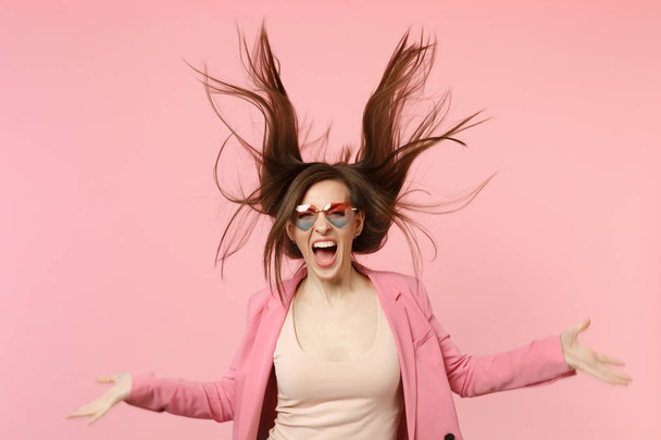 Portrait of wild screaming young woman in heart glasses jumping  - Photo, image