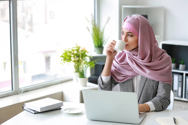 Femme musulmane travaillant sur un ordinateur portable au bureau
 - Photo, image