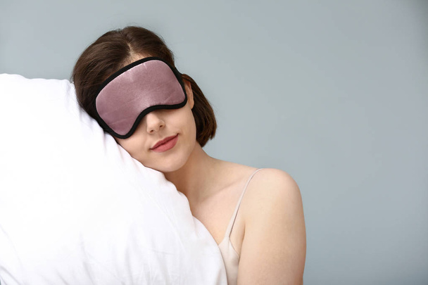 Renk arka planda maske ve yastık ile uykulu kadın - Fotoğraf, Görsel