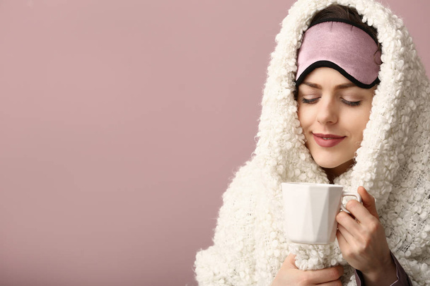 Молодая женщина в маске для сна, чашка кофе и клетка на цветном фоне
 - Фото, изображение