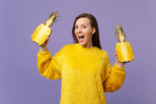 Podekscytowany młoda kobieta w futro sweter utrzymanie usta otwarte Halfs trzymać świeżych dojrzałych owoców ananasa na białym tle pastelowych tle. Ludzie żywy styl życia, relaks koncepcja wakacje. Makiety przestrzeni kopiowania. - Zdjęcie, obraz