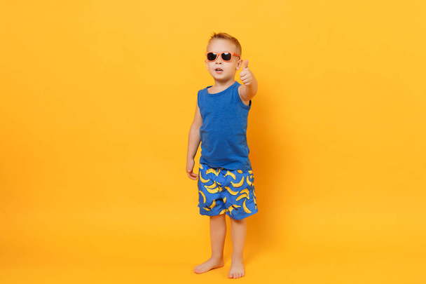 lächelnder lustiger Junge 3-4 Jahre alt mit blauem Strandsommerkleid - Foto, Bild
