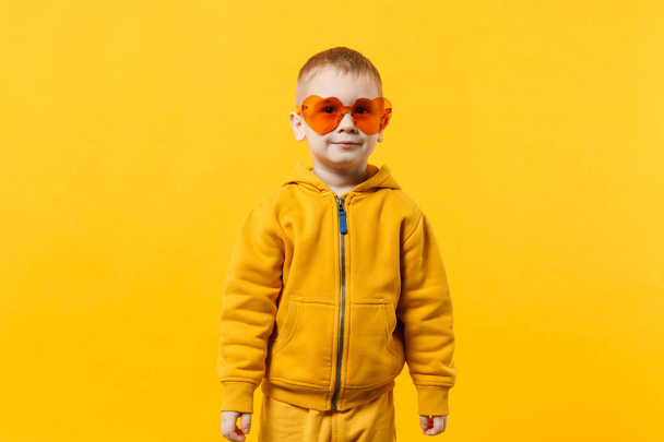 Pieni söpö lapsi poika poika 3-4 vuotta vanha yllään keltaisia vaatteita eristää
 - Valokuva, kuva