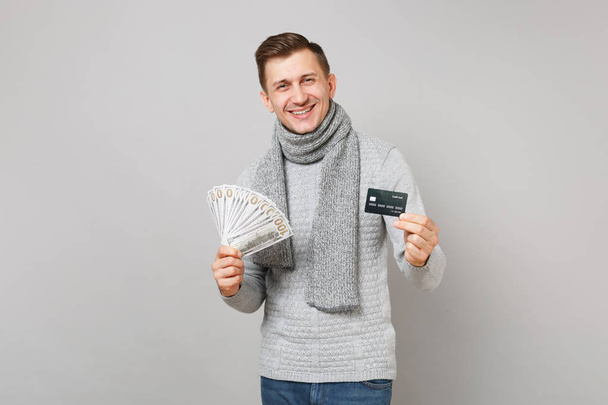 Laughing young man in gray sweater, scarf hold lots bunch of dol - Foto, afbeelding