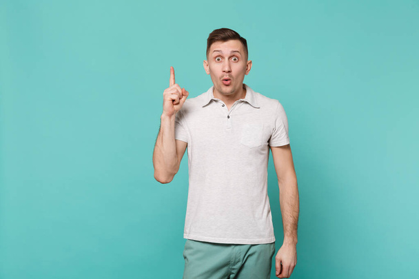 Porträt eines verblüfften jungen Mannes in lässiger Kleidung mit Zeigefinger - Foto, Bild