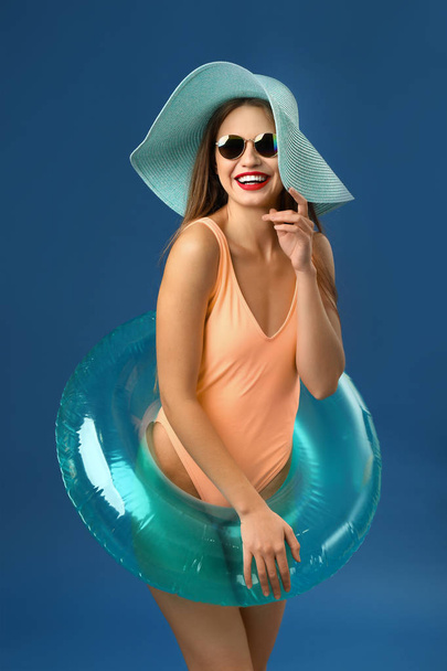 Beautiful young woman with inflatable ring on color background - Photo, Image