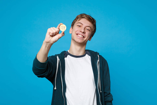 Portrét usmívajícího se mladého muže v příležitostných šatech s držením mincí, - Fotografie, Obrázek