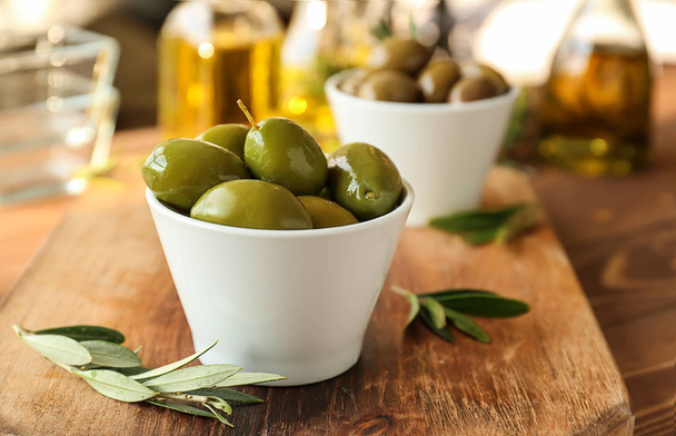 Bowl with tasty olives on wooden board, closeup - Photo, Image