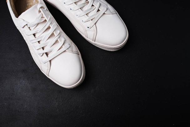 Stylish white sneakers on black background - Fotoğraf, Görsel